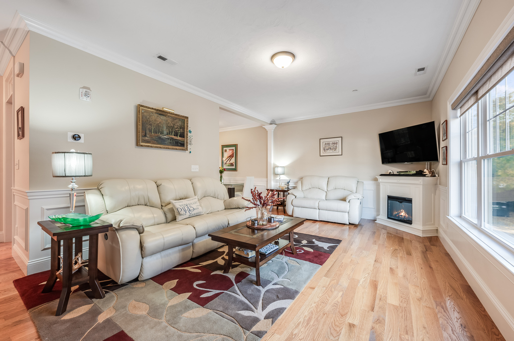 a living room with furniture a fireplace and a flat screen tv