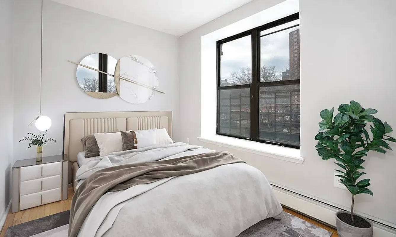 a bedroom with a large bed and a potted plant