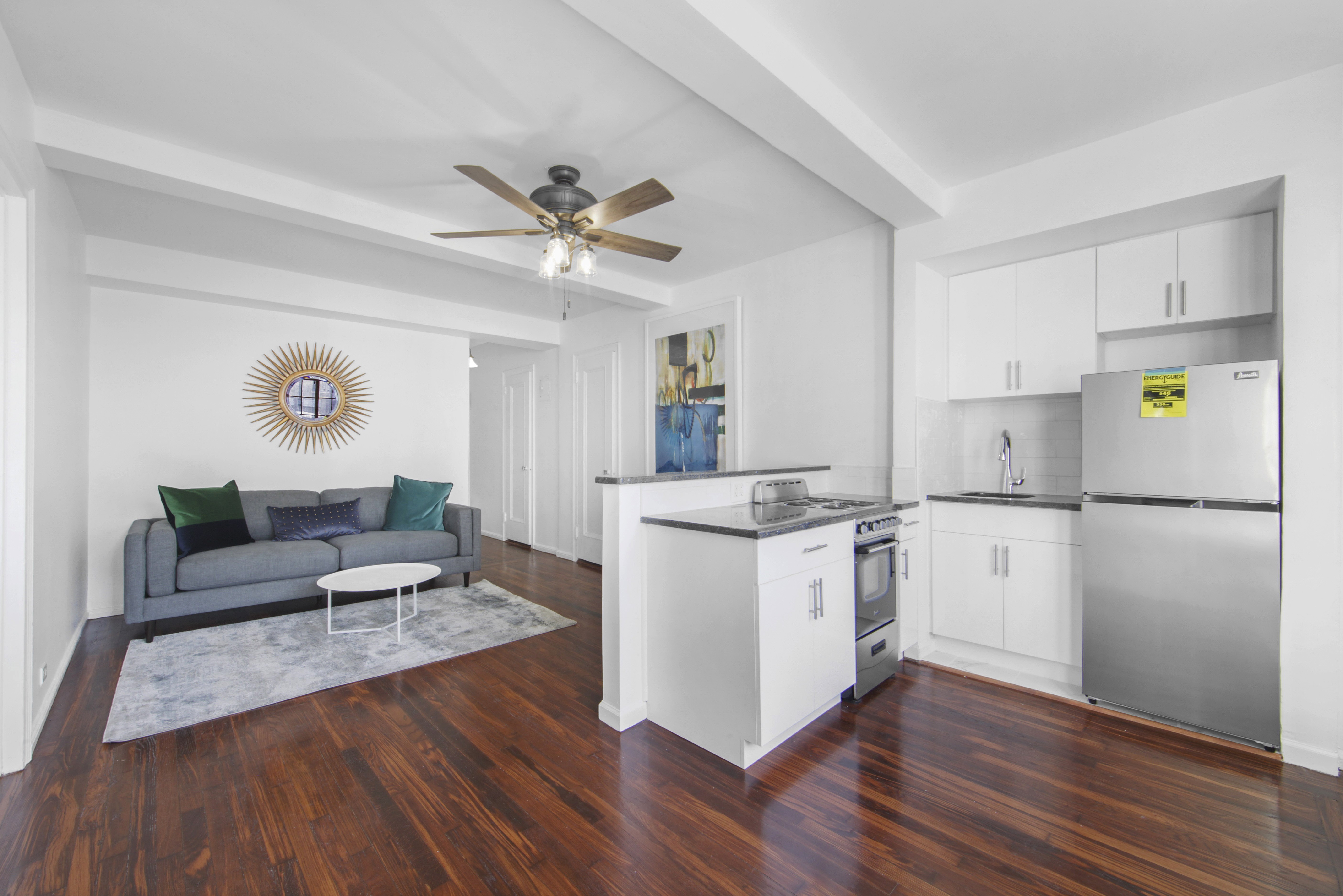 a kitchen with a refrigerator a stove cabinets and wooden floor