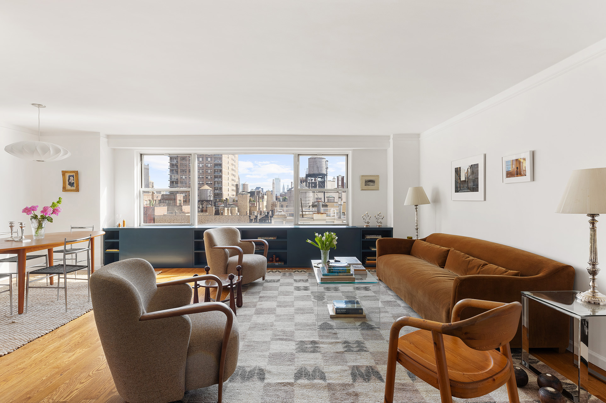 a living room with furniture kitchen view and large windows