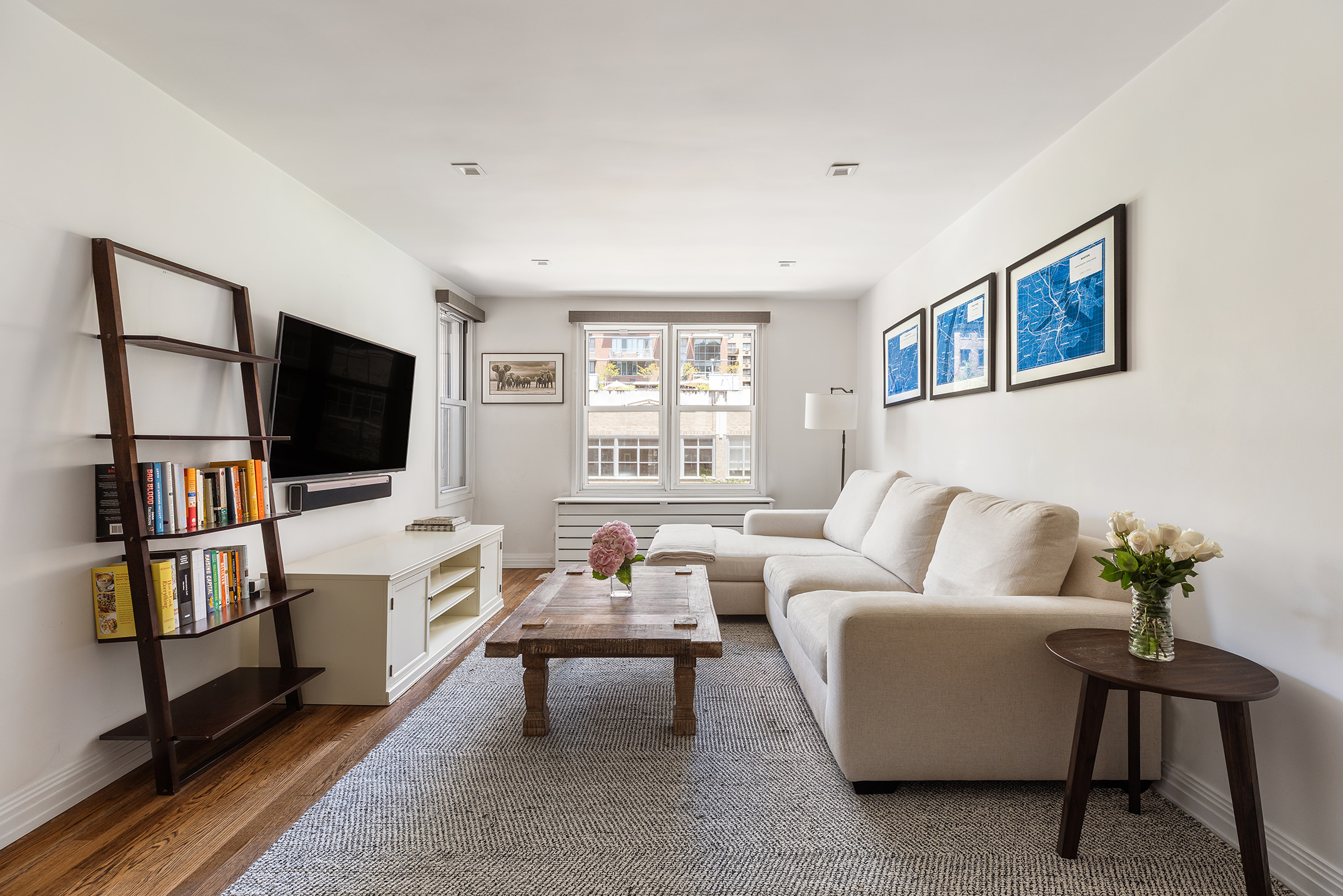 a living room with furniture a flat screen tv and a window