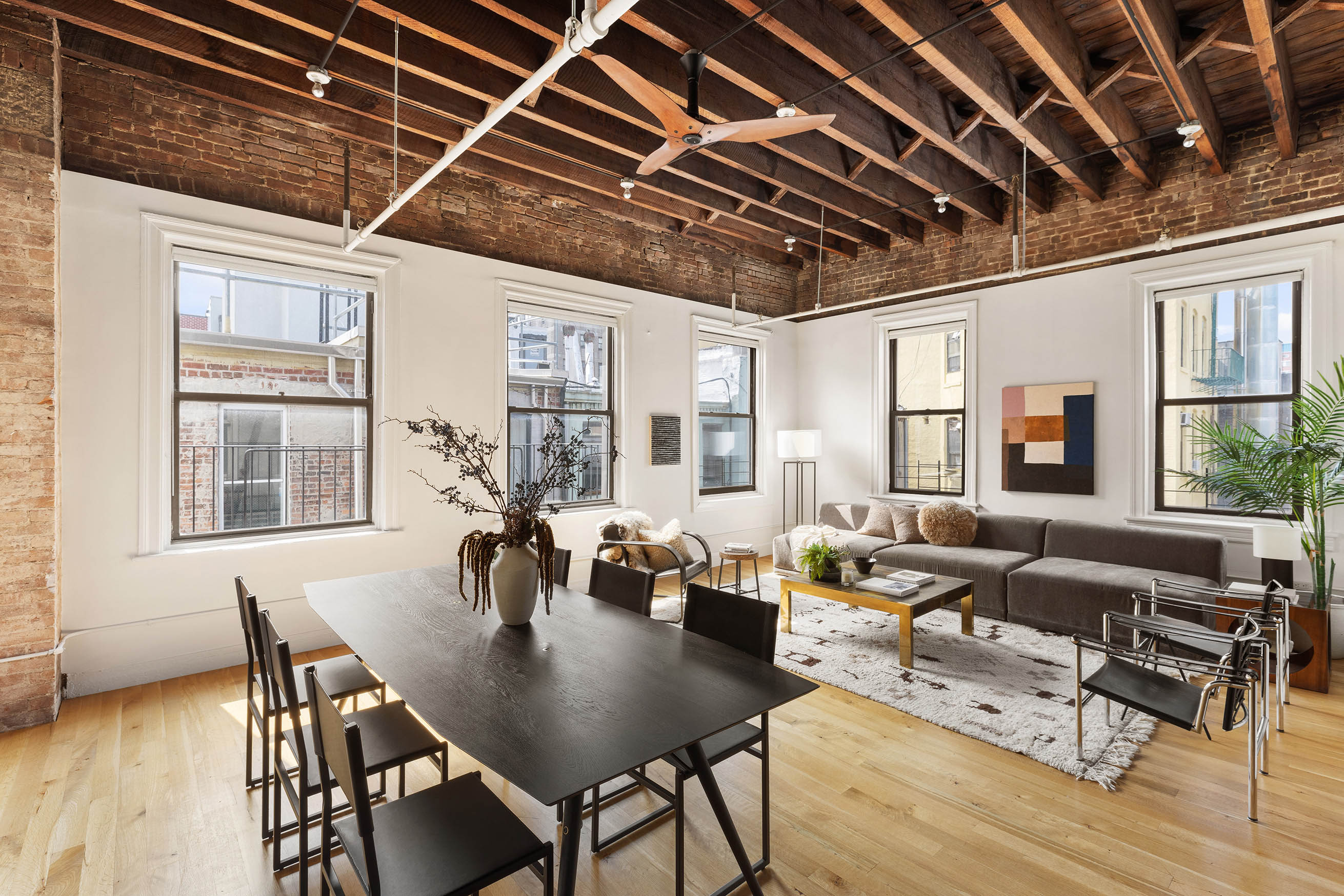 a living room with furniture wooden floor dining table and a window