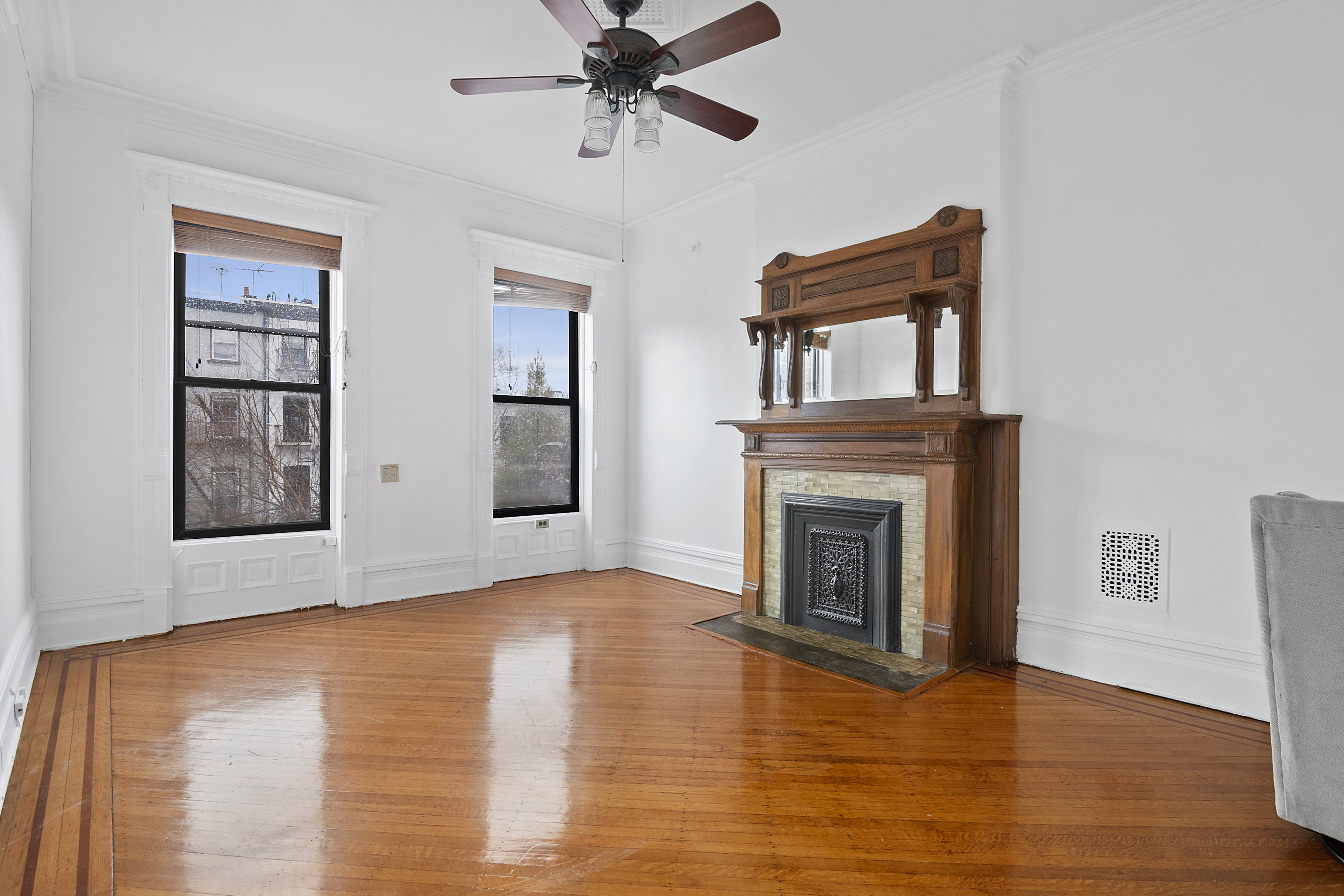 a view of empty room with wooden floor and fireplace