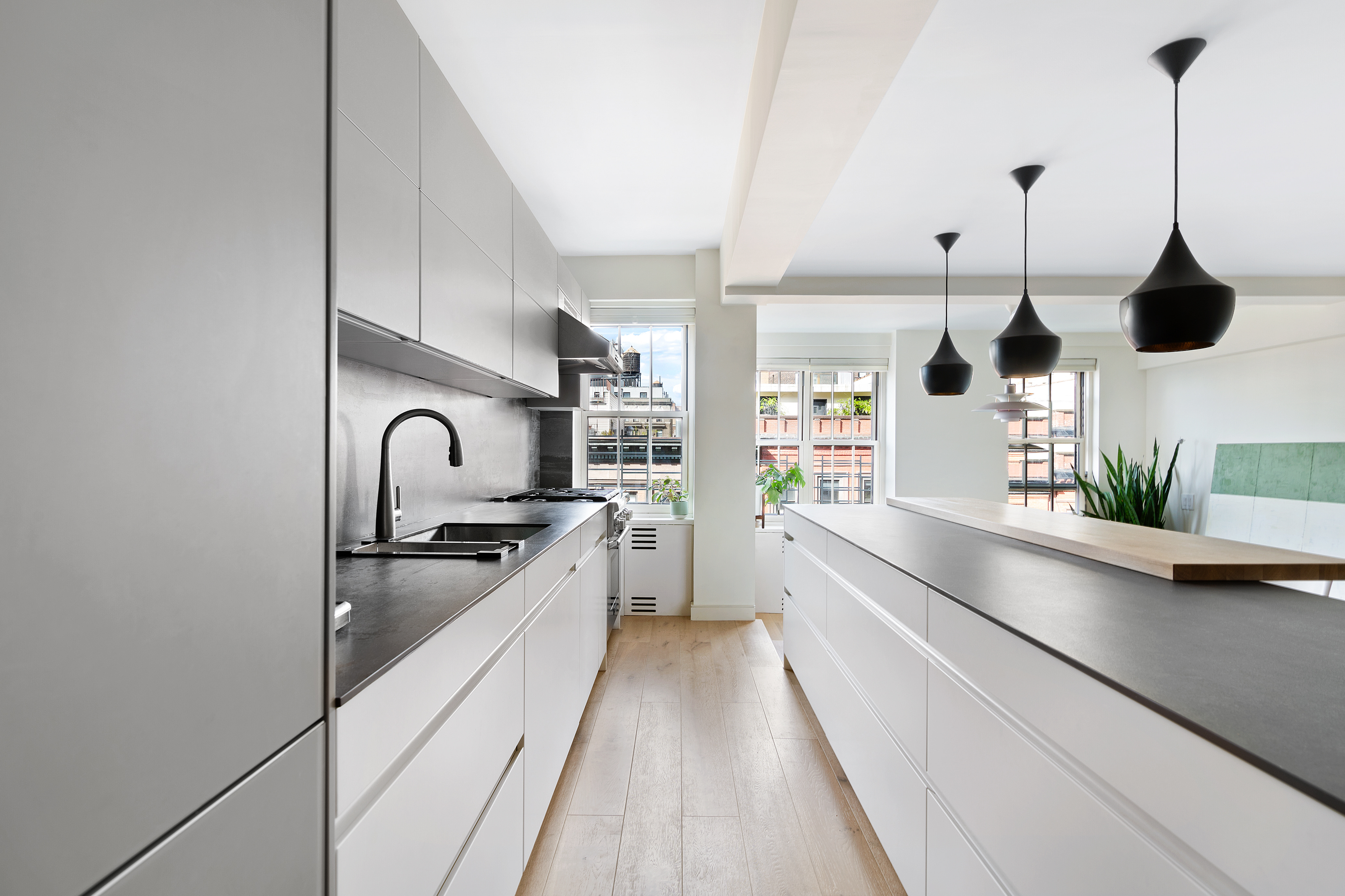 a kitchen with stainless steel appliances granite countertop a sink a stove and a wooden floors