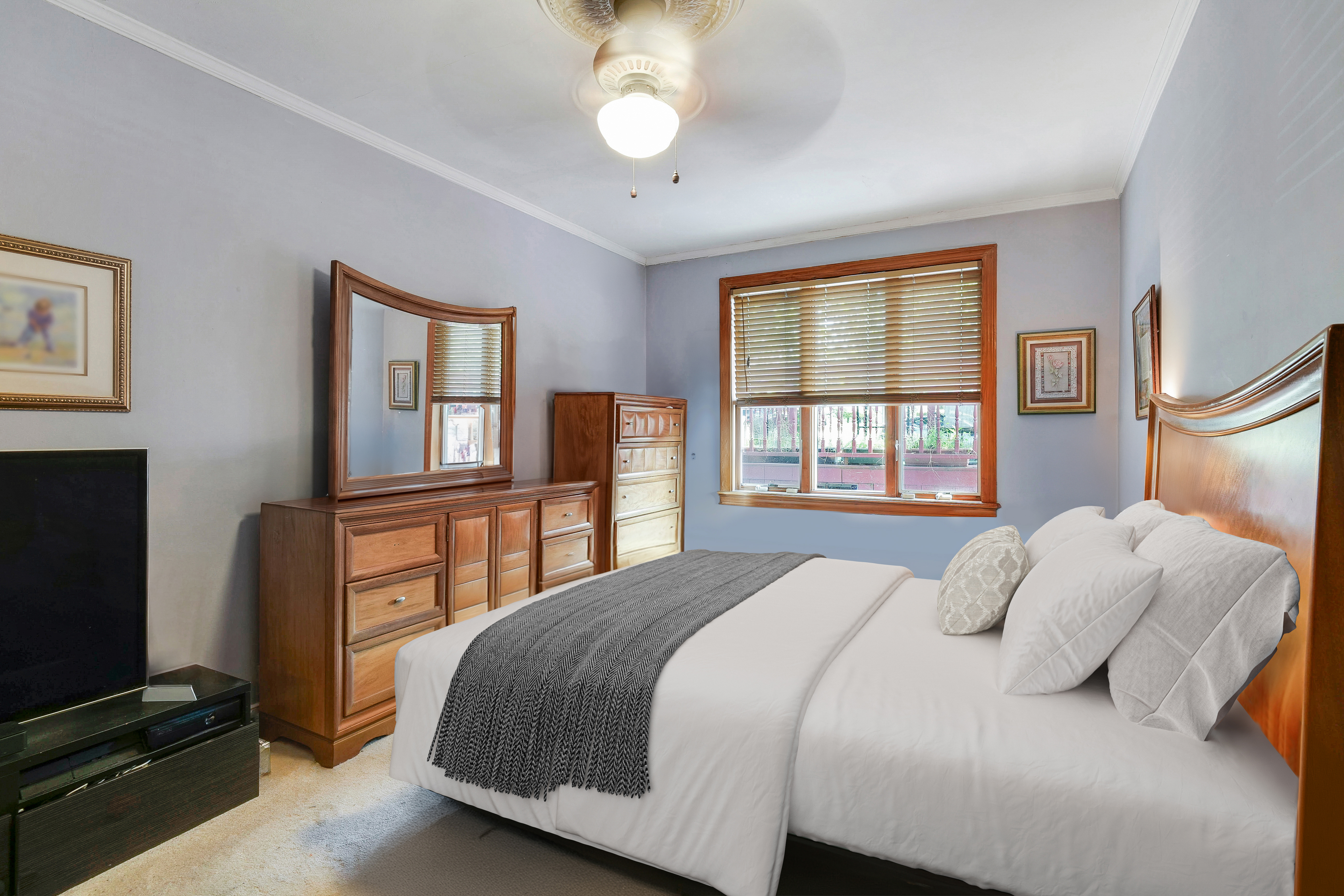 a bedroom with a bed and a flat tv screen on dresser