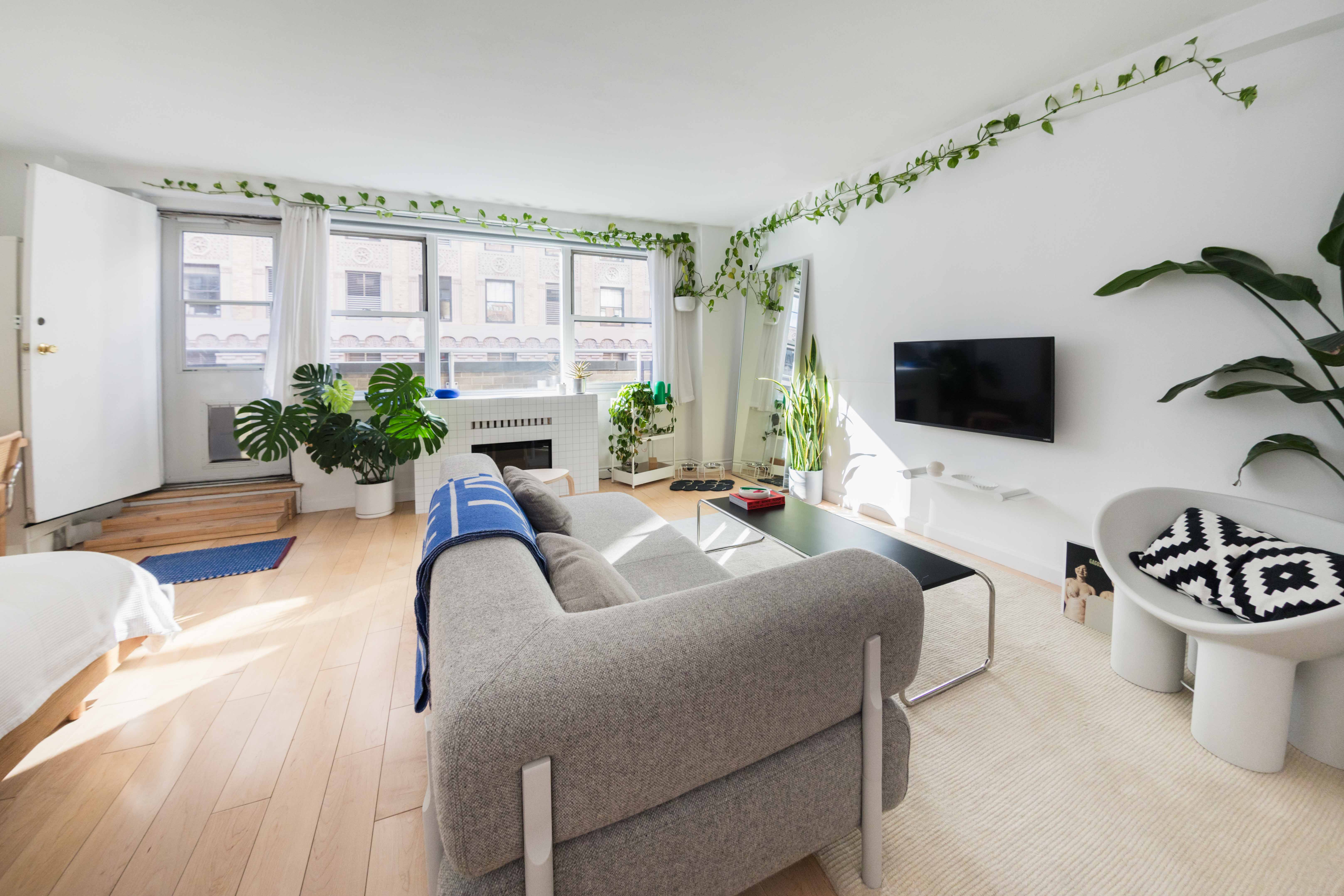 a living room with furniture a flat screen tv and a large window