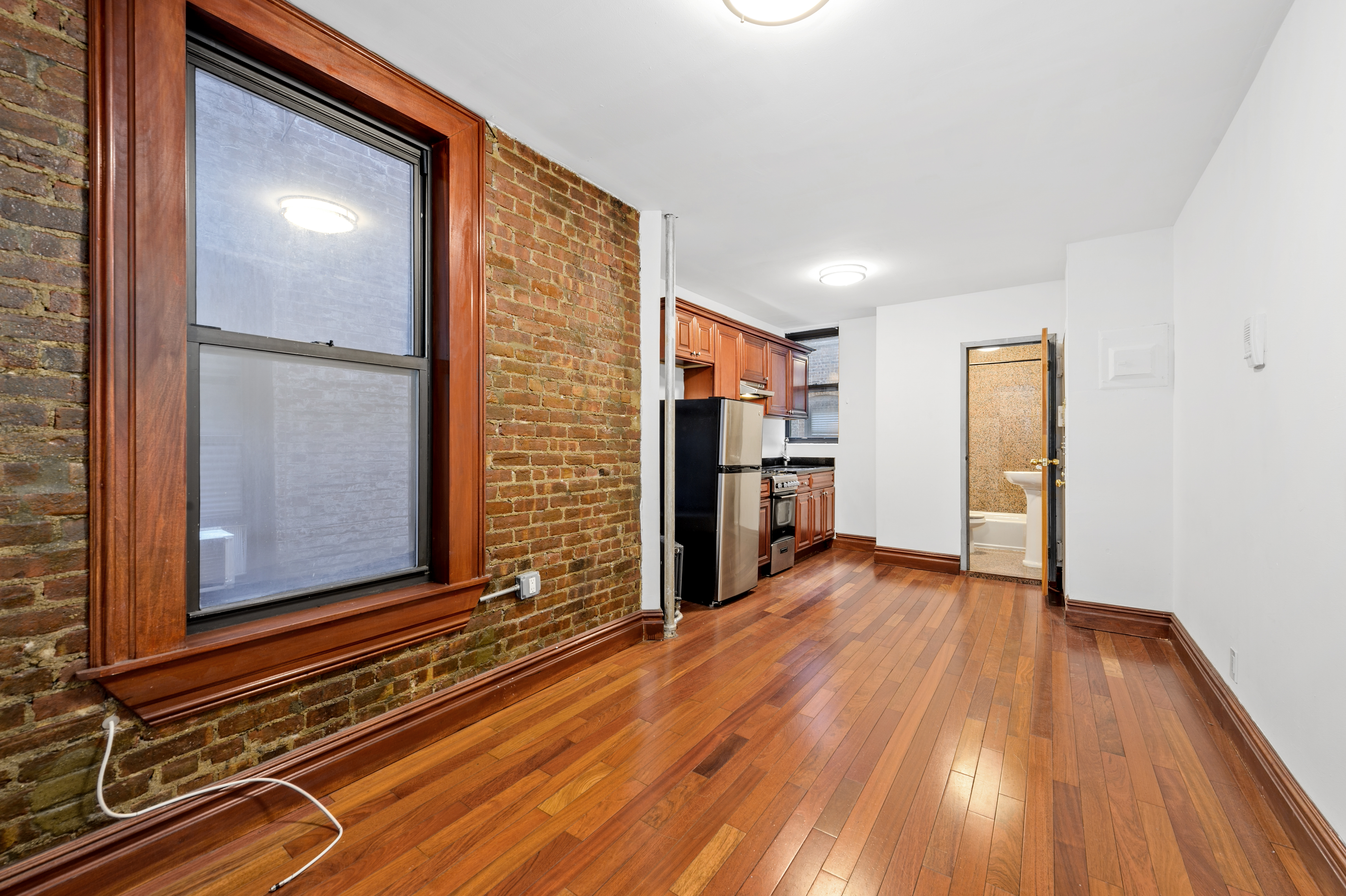 a view of empty room with wooden floor