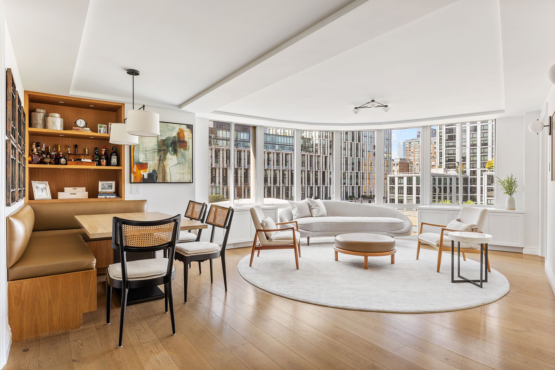 a dining room with furniture large windows and wooden floor