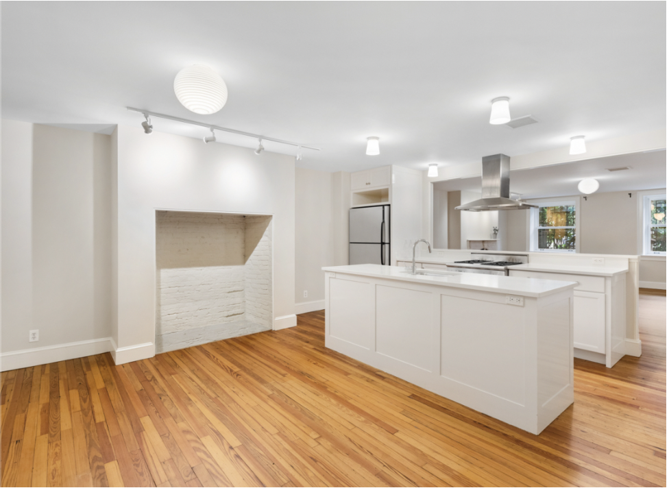 a large white kitchen with kitchen island a sink stainless steel appliances and cabinets