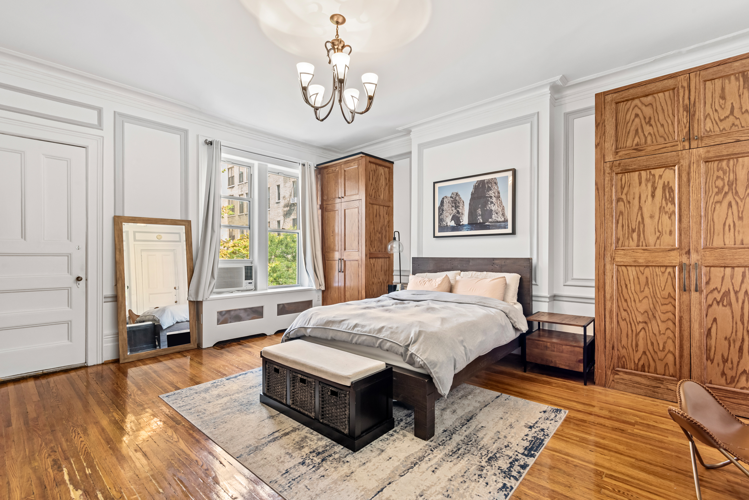 a bed sitting in a spacious bedroom next to a window