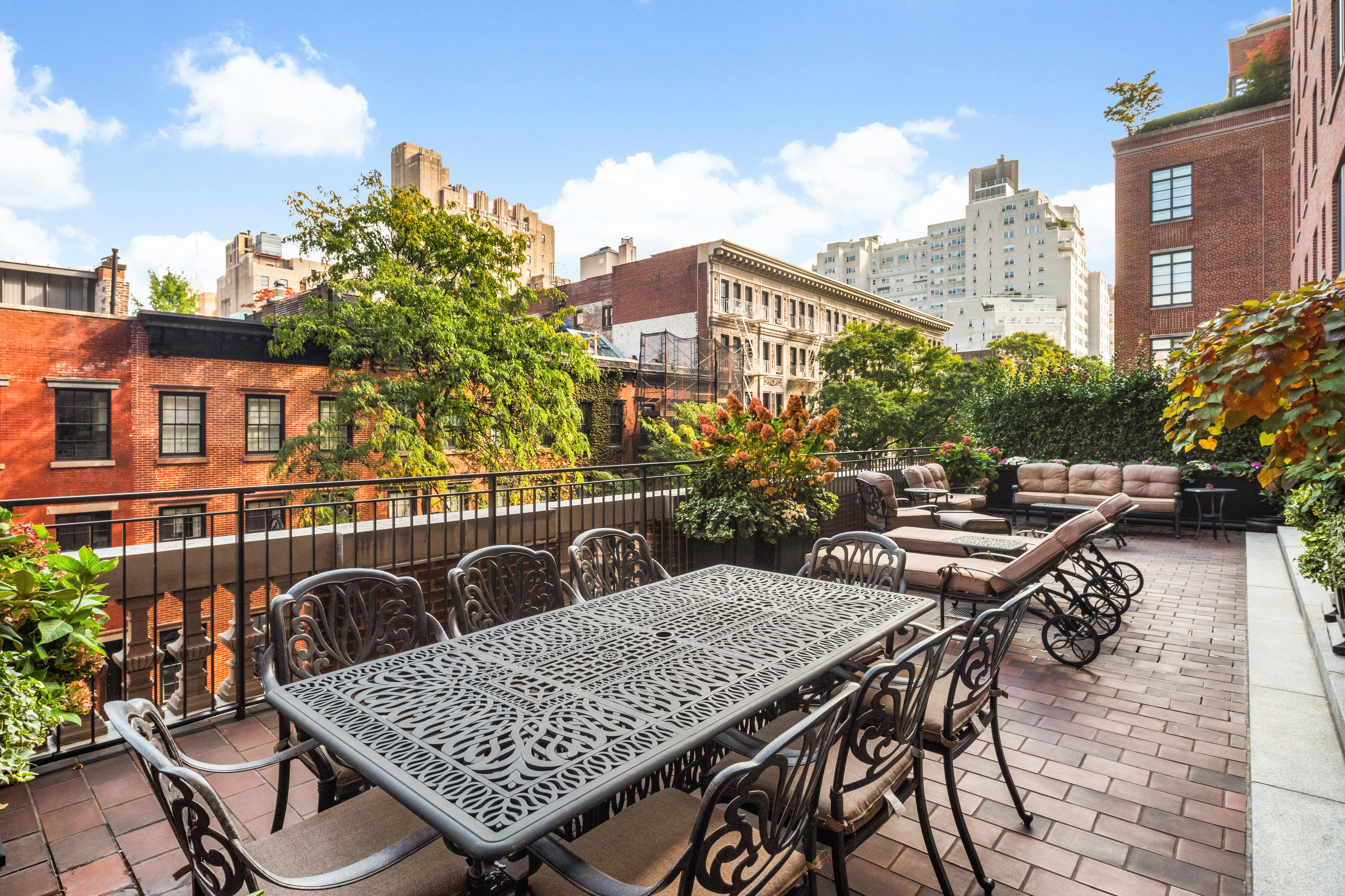 a view of a roof deck with couches and potted plants