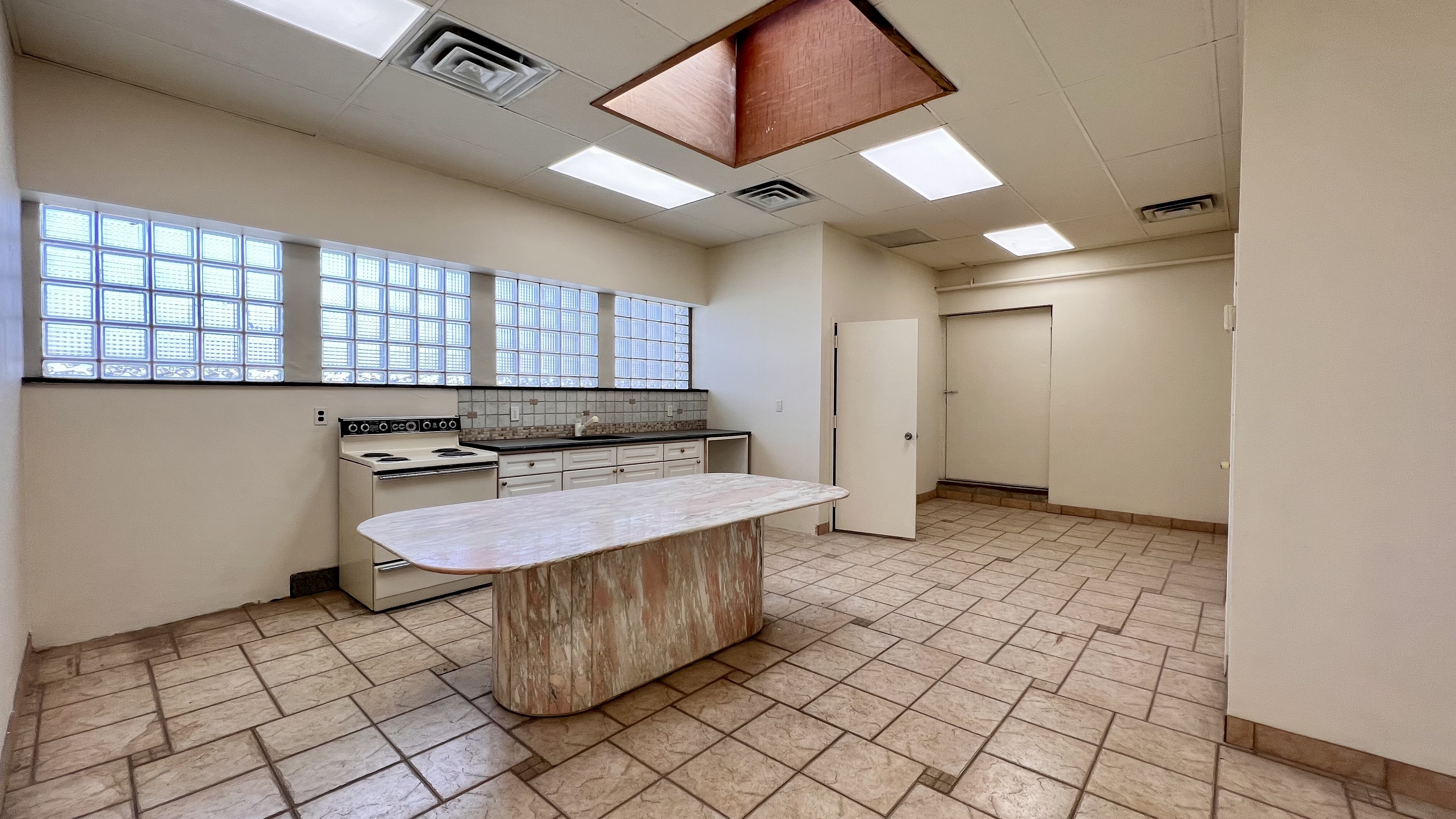 a kitchen with a sink a stove cabinets and a window