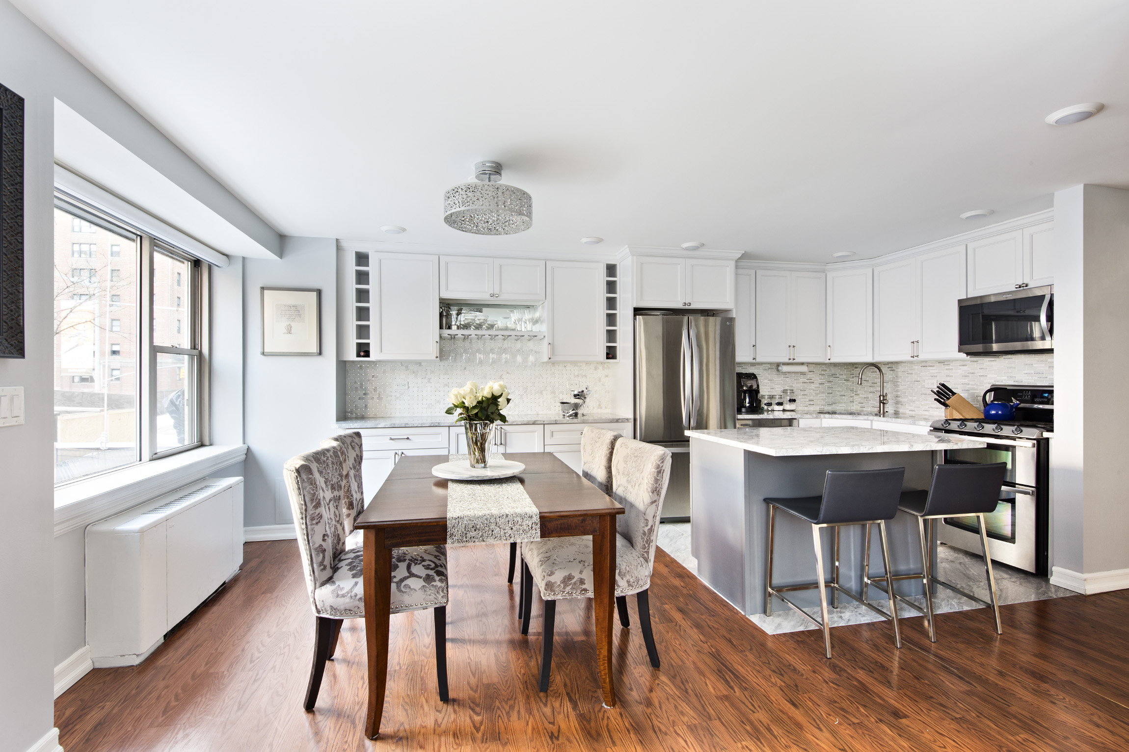 a view of a dining room with furniture a kitchen and chandelier