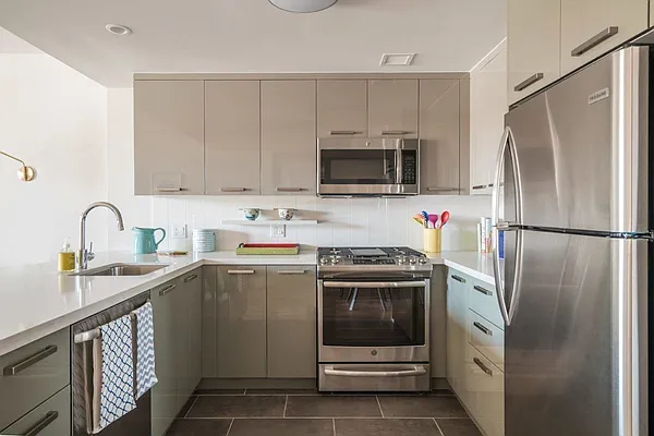 a kitchen with cabinets stainless steel appliances and a sink