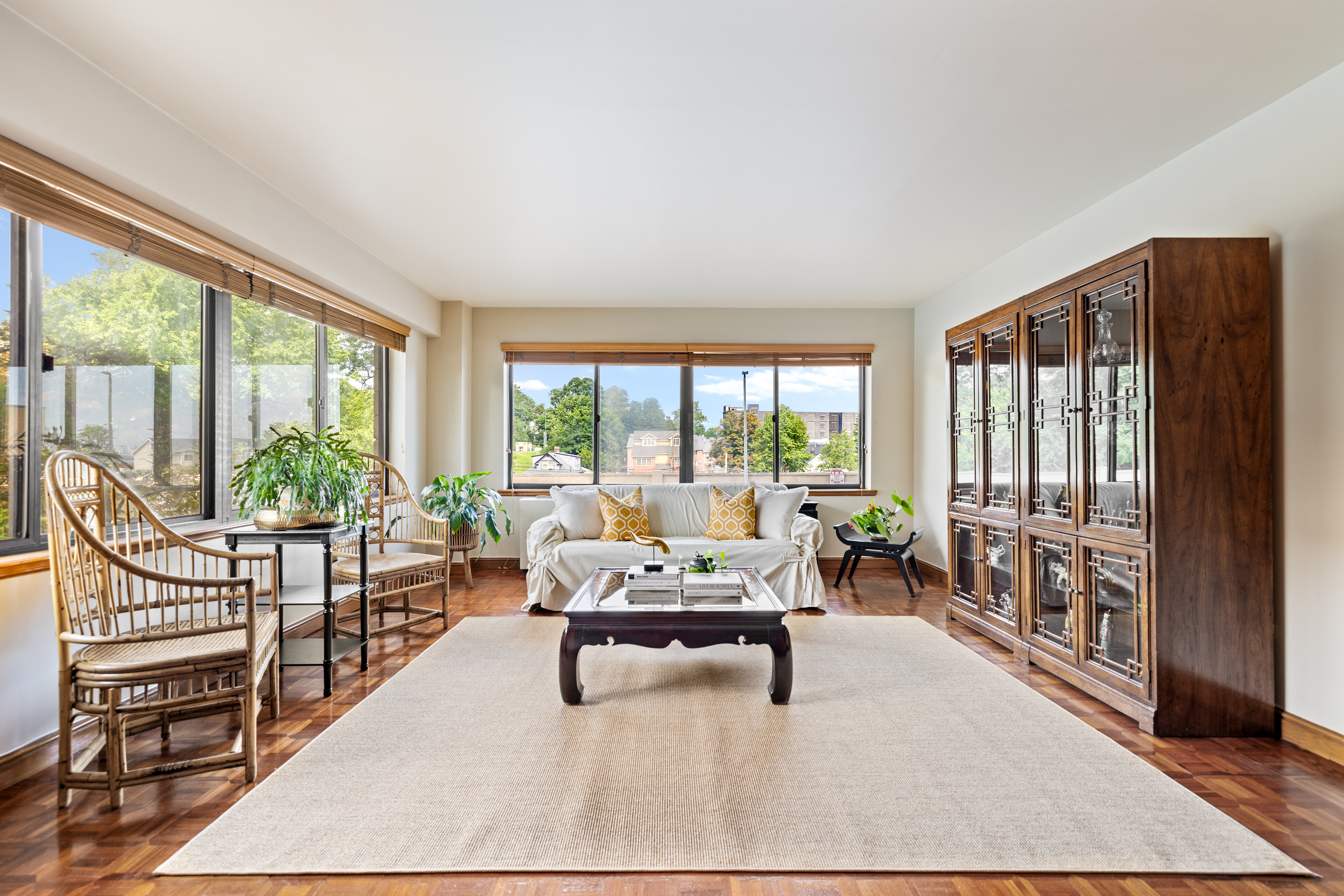 a living room with furniture and a large window with wooden floor