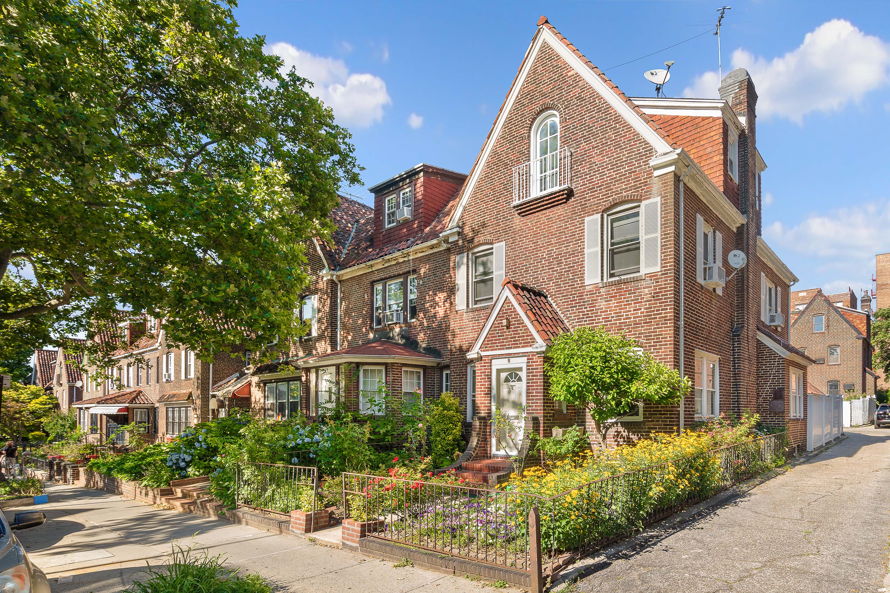 a view of a brick house with many windows next to a yard