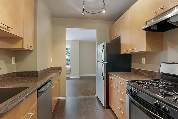 a kitchen with granite countertop a stove and a refrigerator