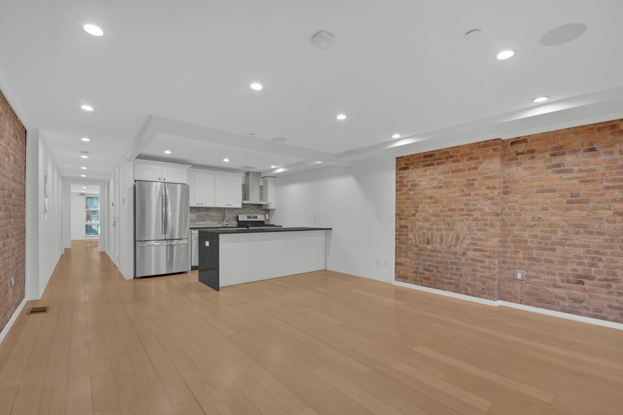 a large white kitchen with kitchen island a stove a sink and a refrigerator