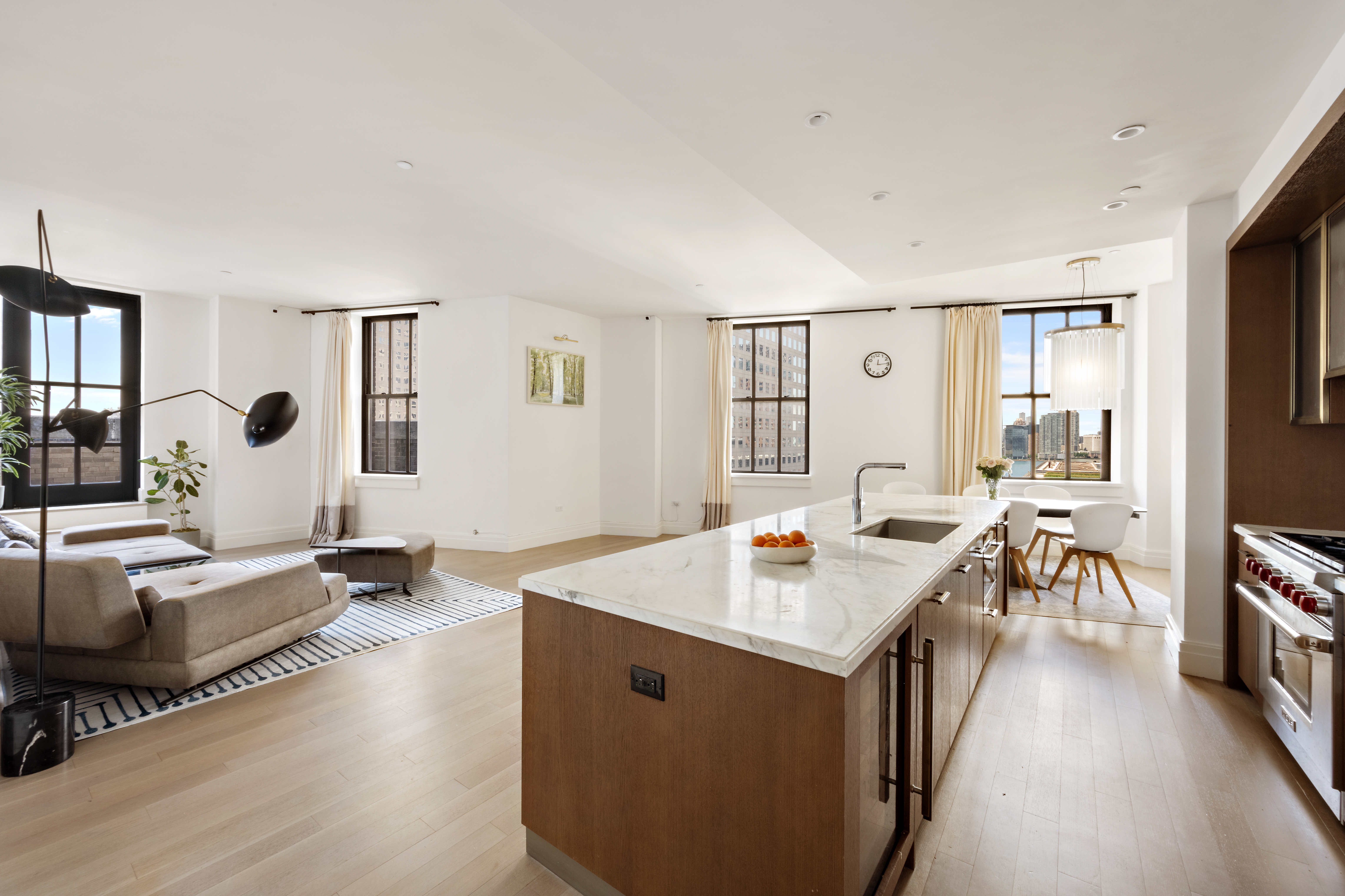 a living room with stainless steel appliances granite countertop furniture and a flat screen tv