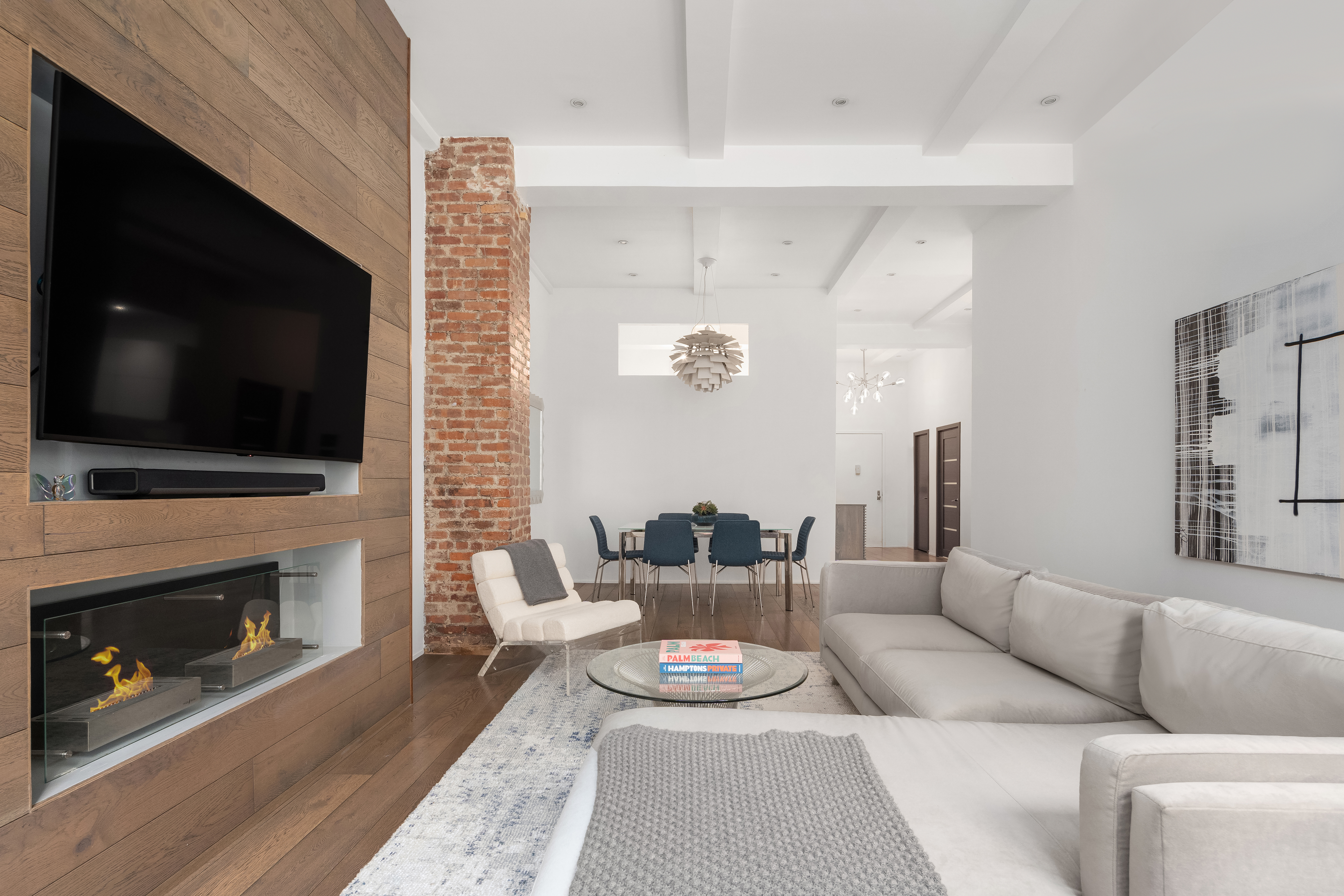 a living room with furniture a flat screen tv and a fireplace