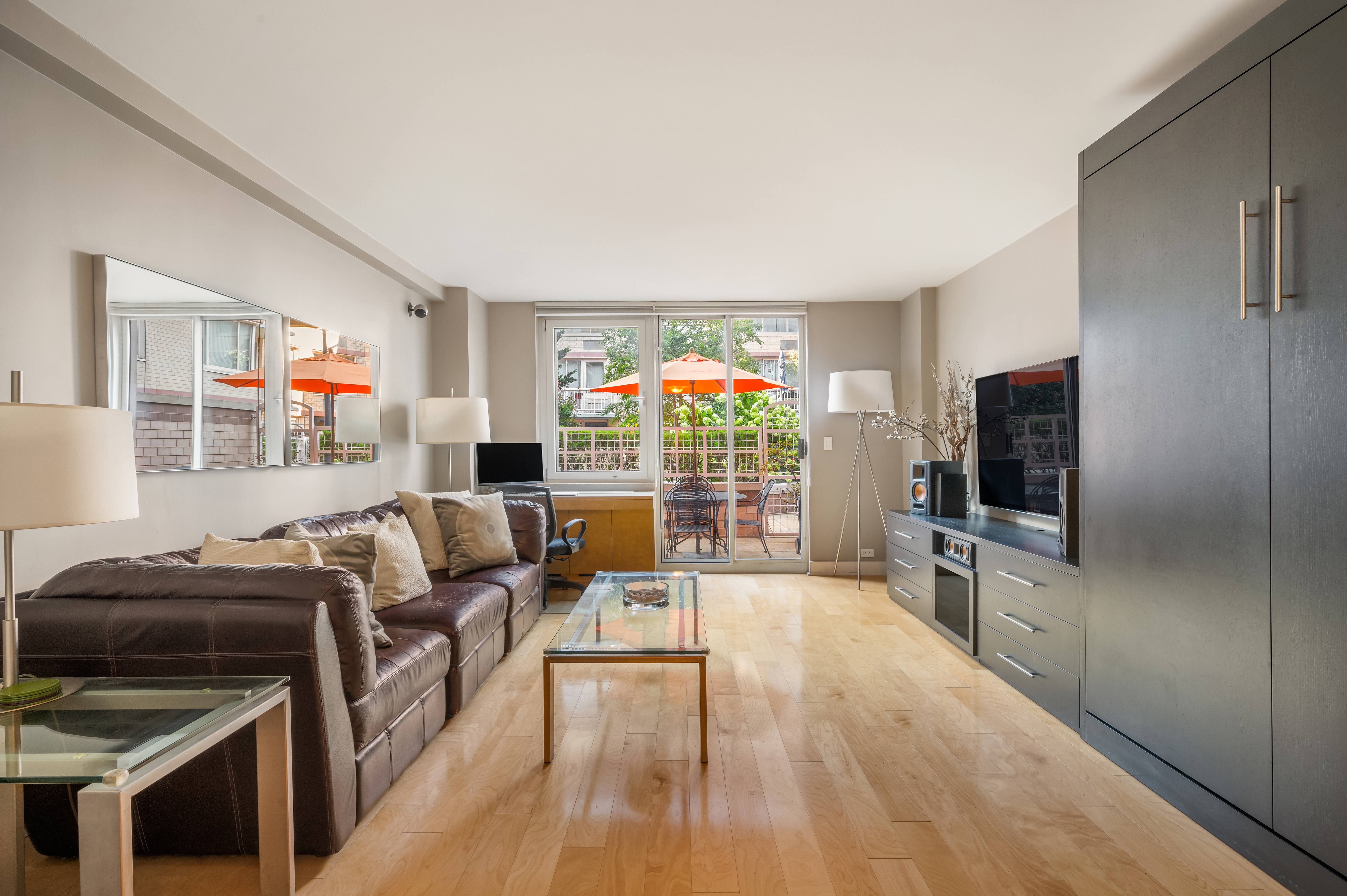 a living room with furniture a flat screen tv and a floor to ceiling window