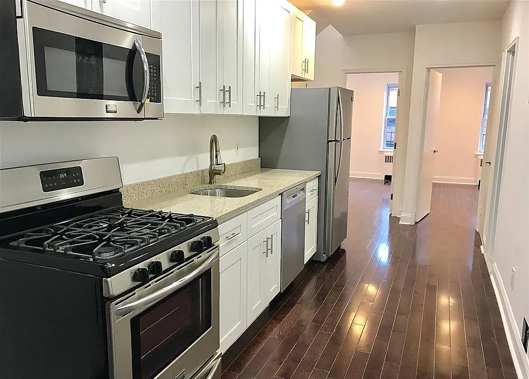 a kitchen with stainless steel appliances a stove microwave and refrigerator