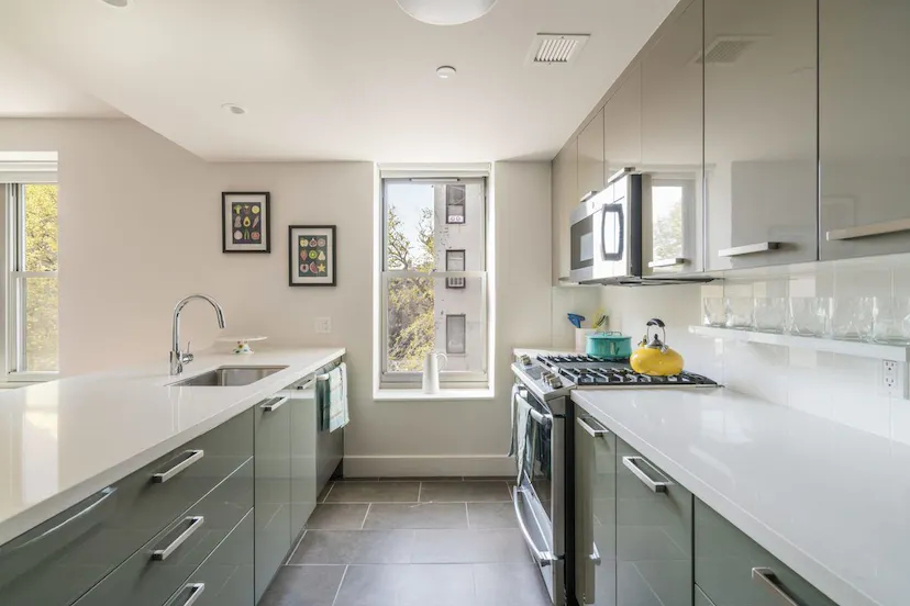 a kitchen that has a sink a stove and cabinets