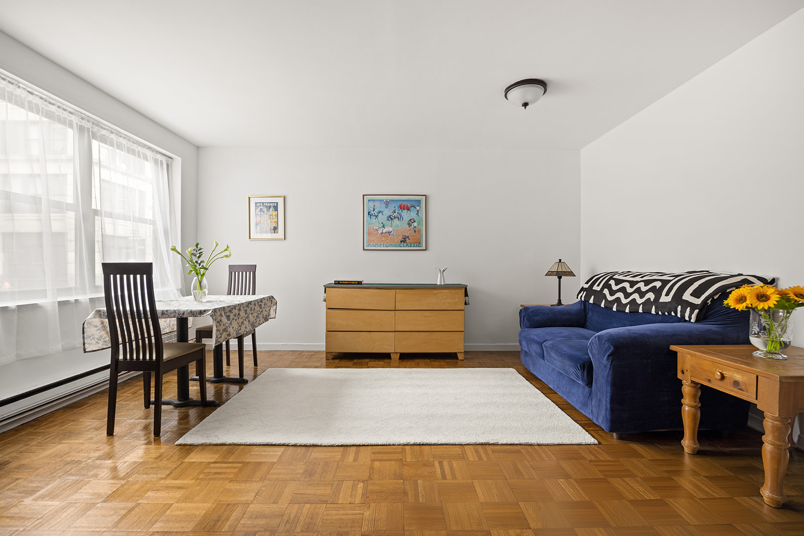 a living room with furniture rug and dining table