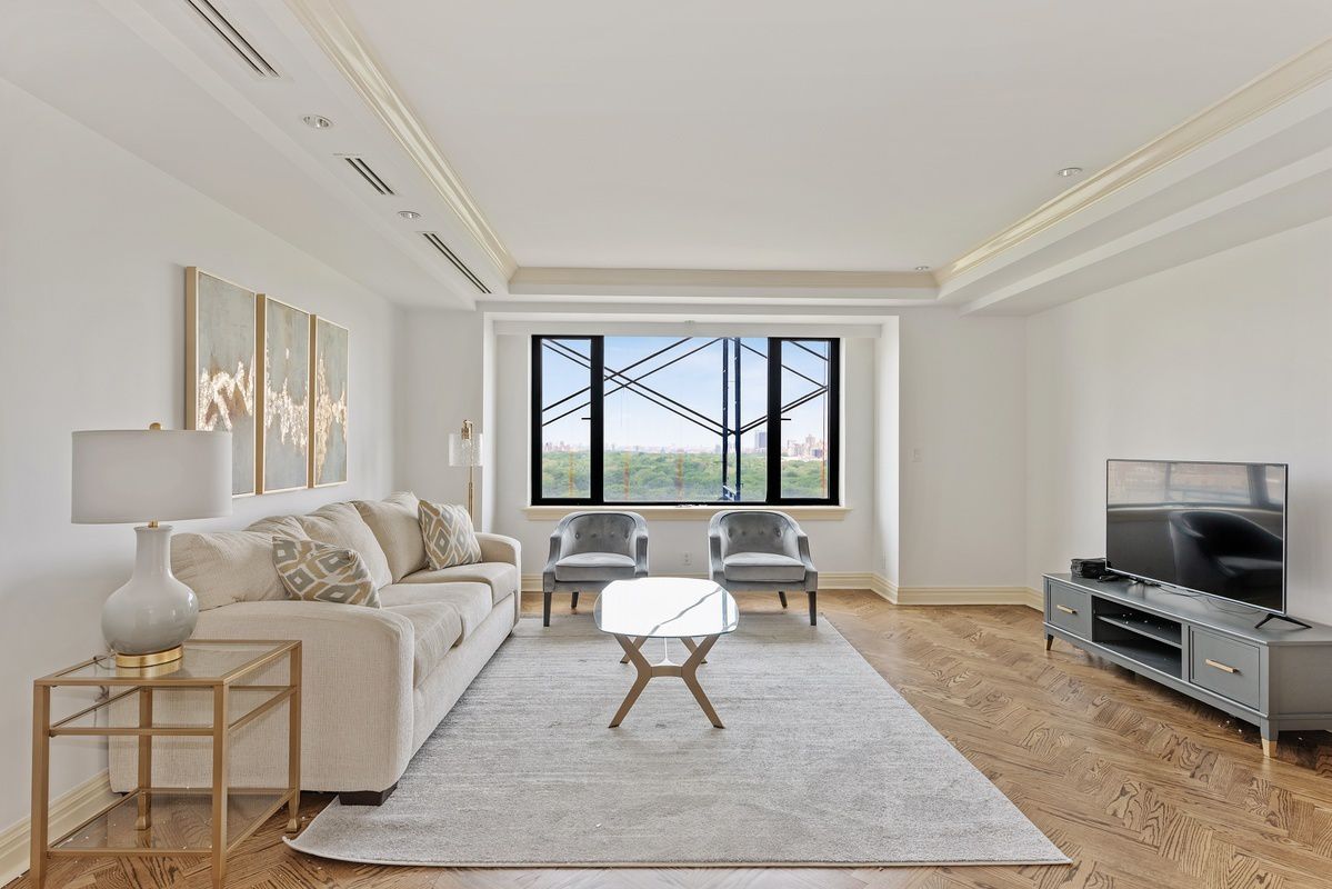 a living room with furniture a flat screen tv and a rug