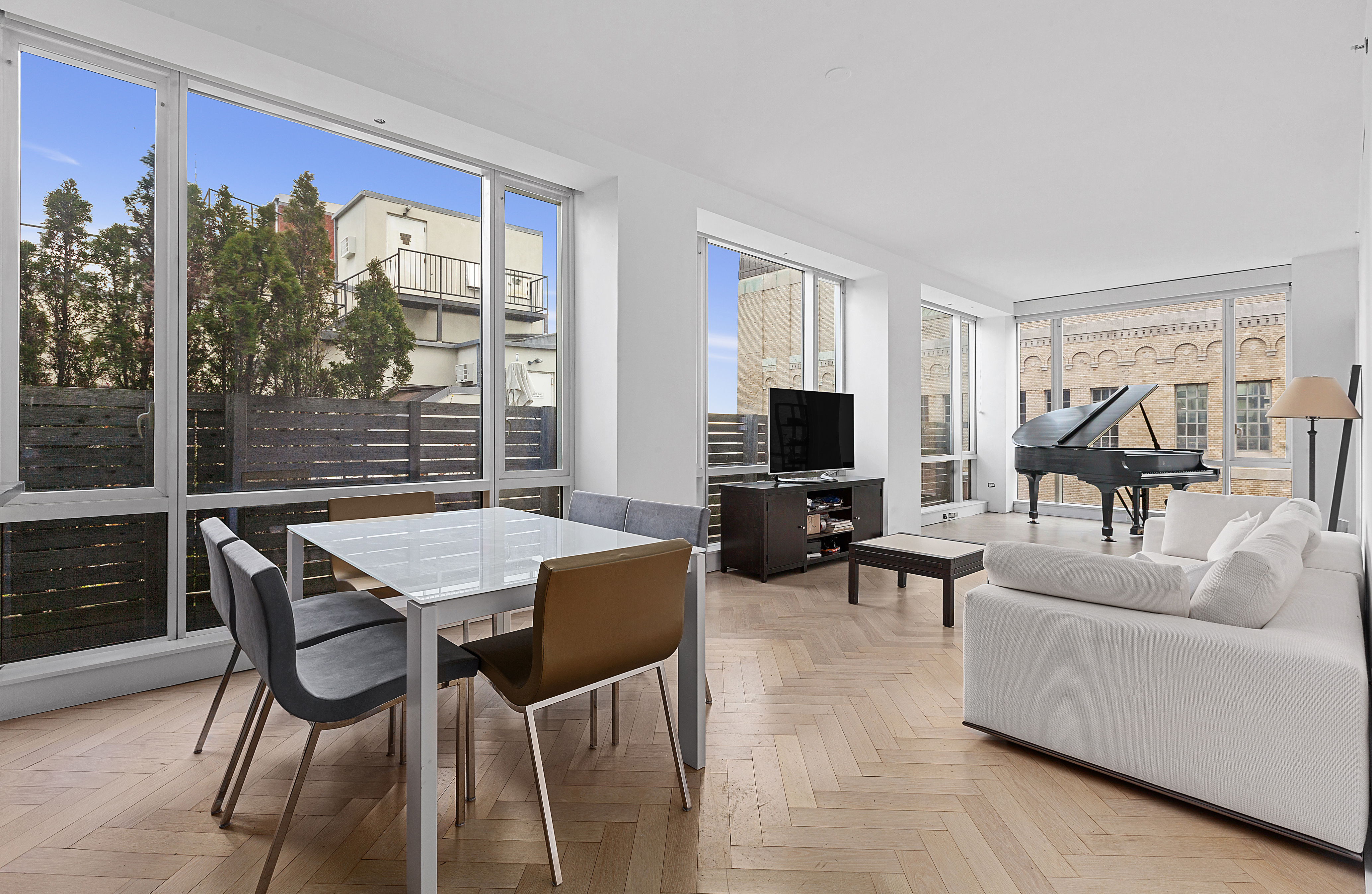 a living room with furniture a flat screen tv and a large window