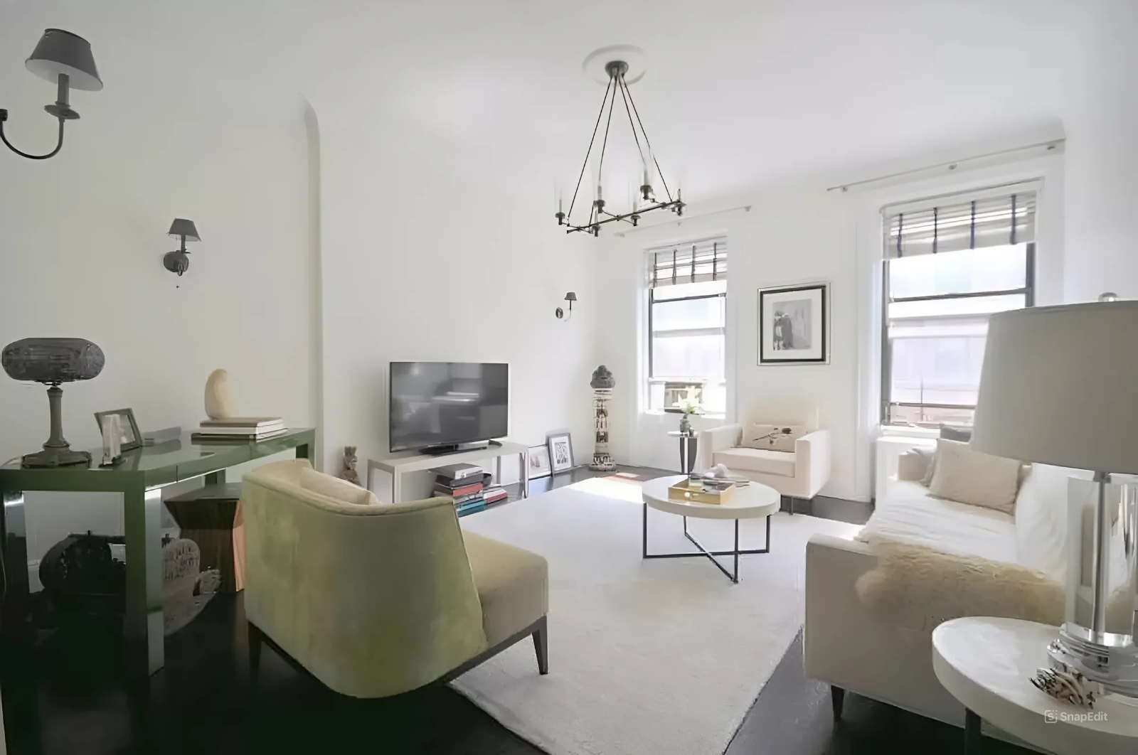 a living room with furniture a chandelier and a flat screen tv