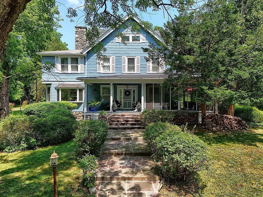 View of front facade featuring a front lawn and covered porch