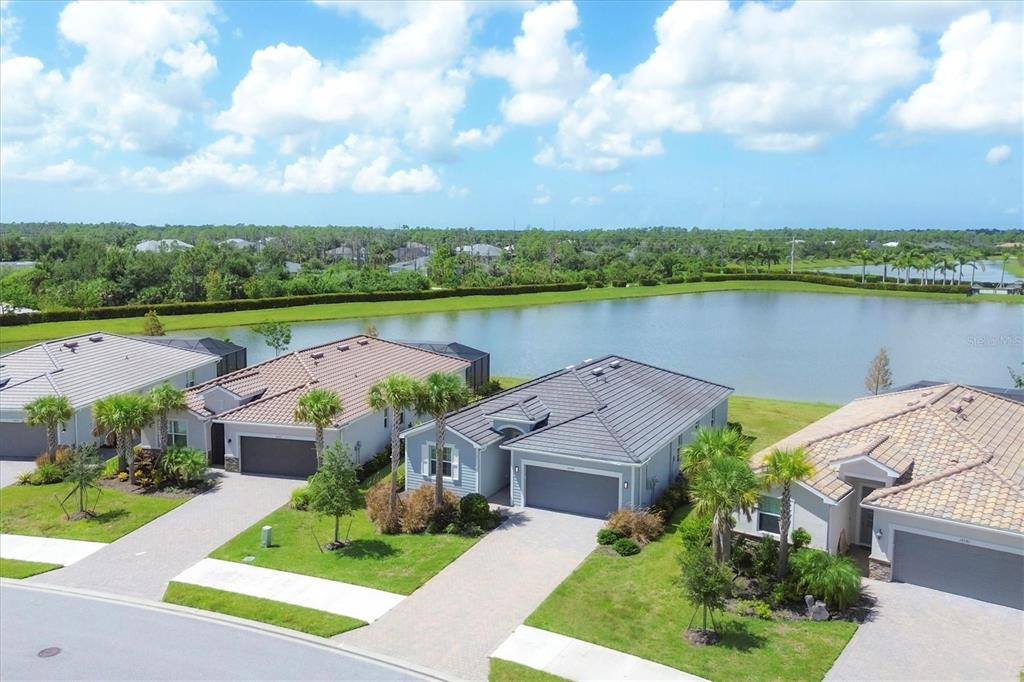 an aerial view of house with yard and lake view in back