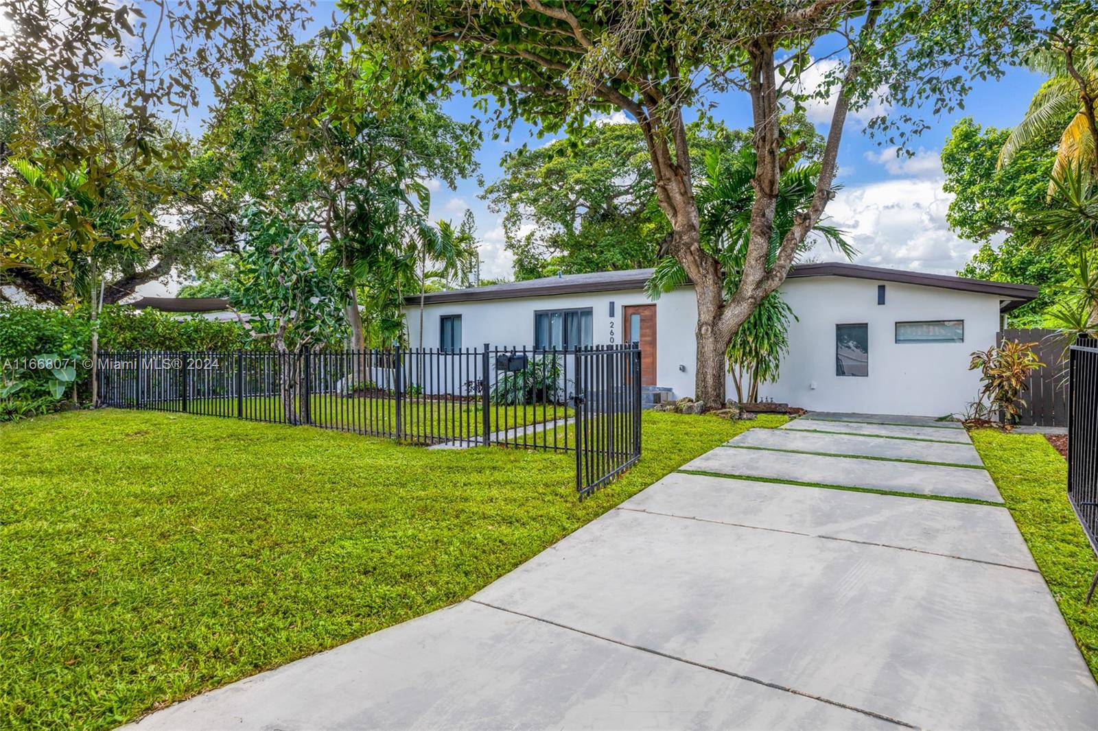 a view of a house with a backyard and a large tree