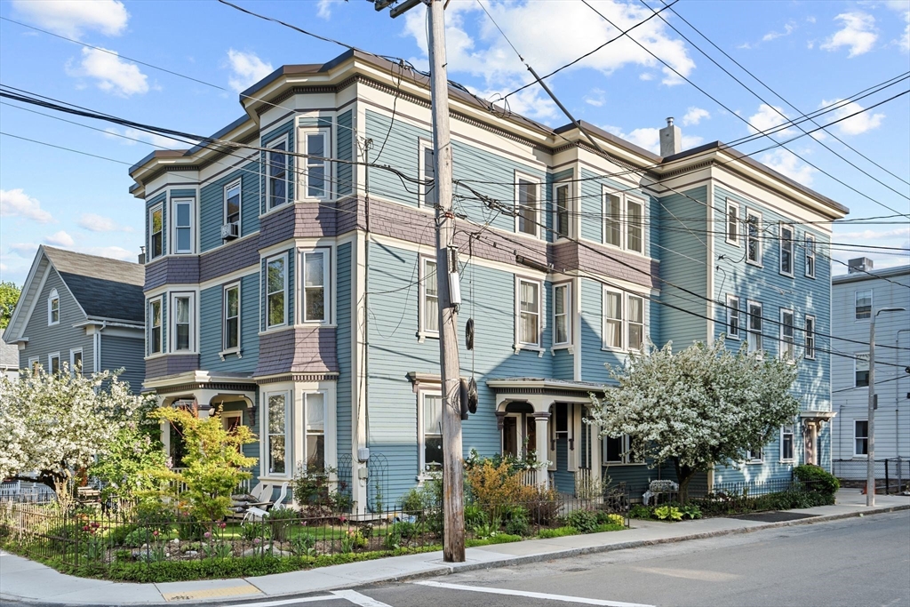 a front view of a multi story residential apartment building with yard and traffic signal