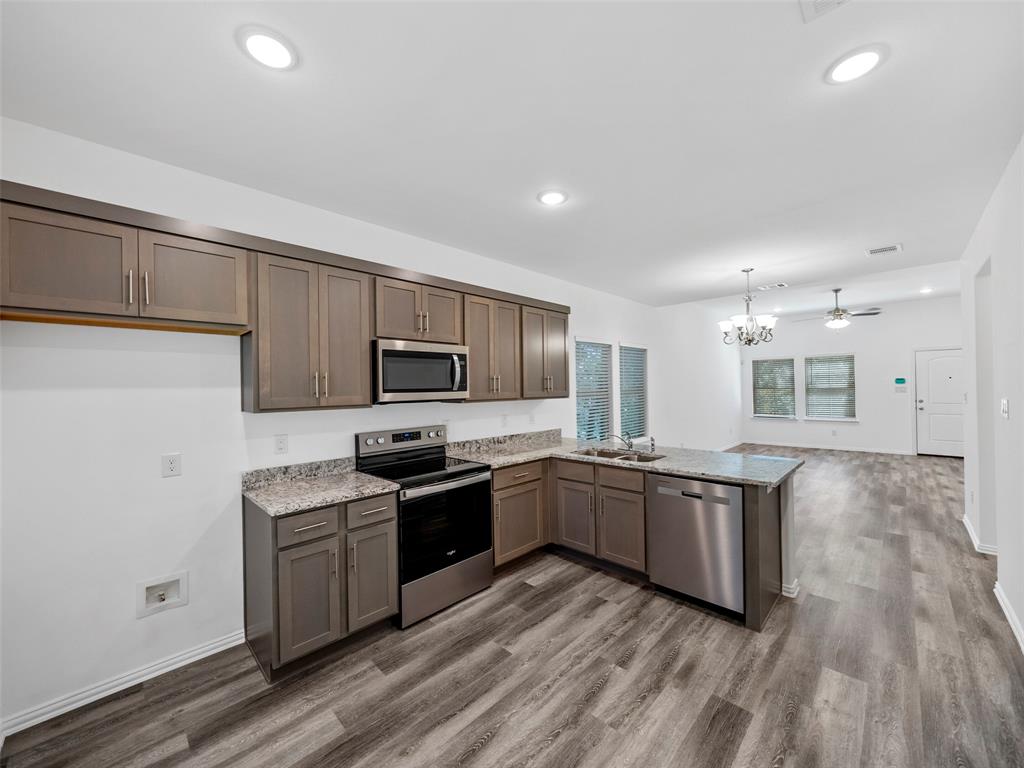 a kitchen with stainless steel appliances granite countertop a sink and stove top oven