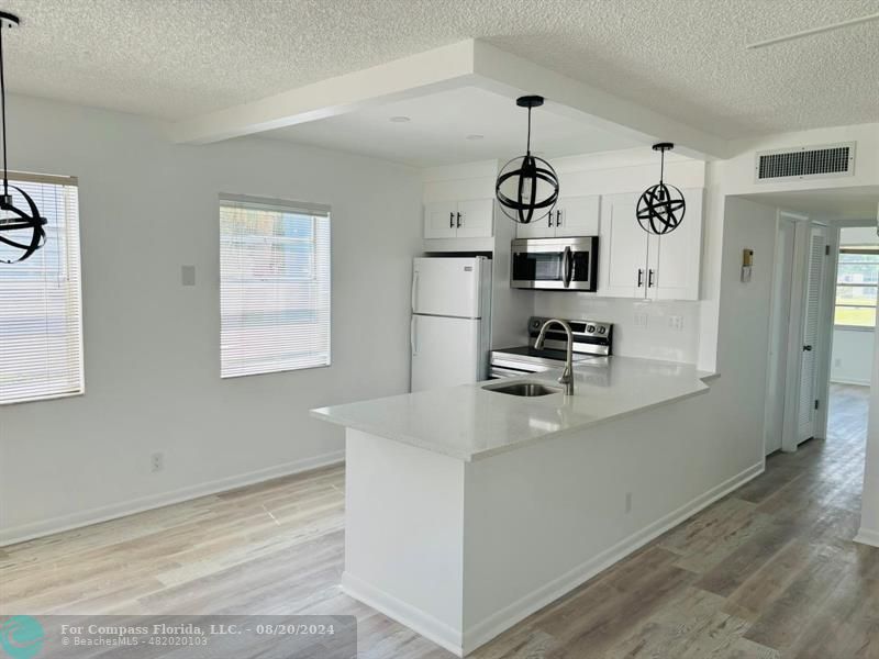 a kitchen with granite countertop cabinets and refrigerator