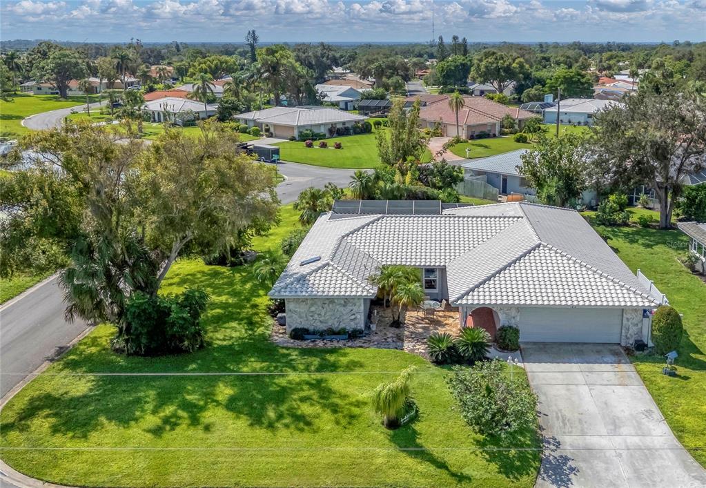 an aerial view of a house with a garden and lake view