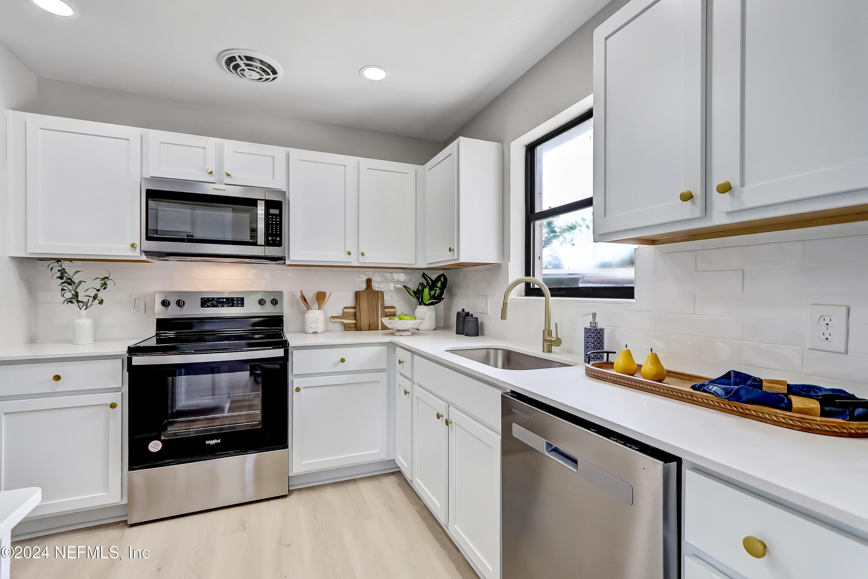 a kitchen with stainless steel appliances granite countertop a sink a stove microwave and cabinets