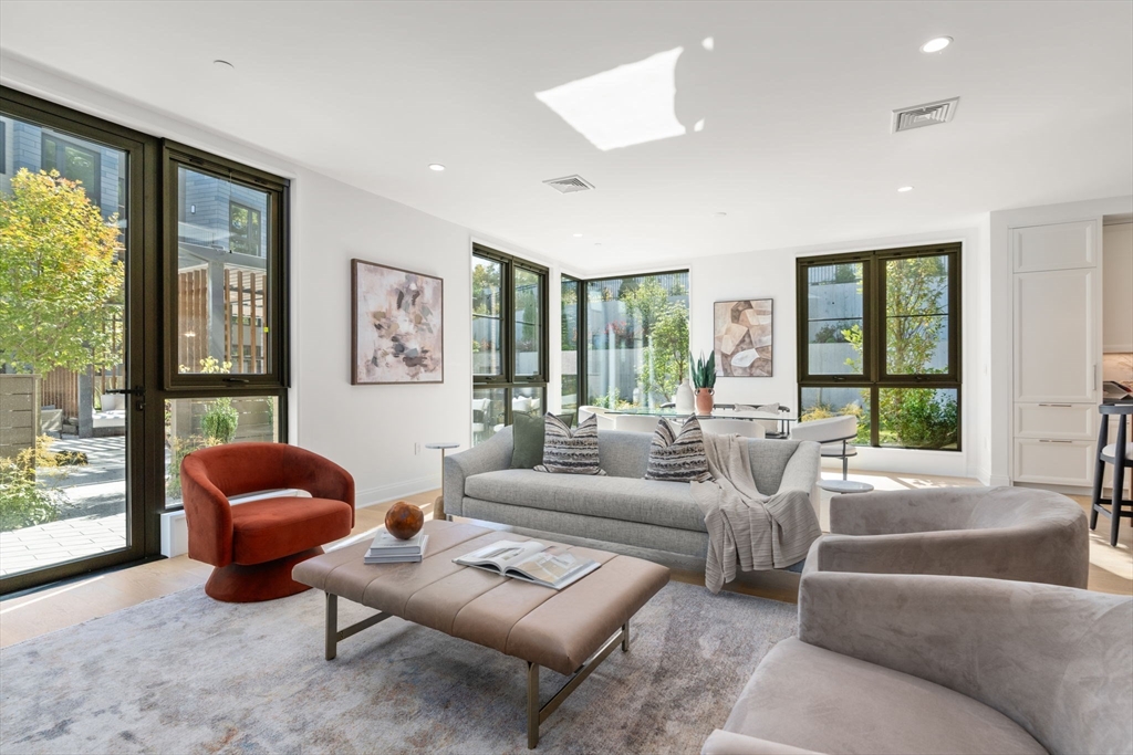 a living room with furniture and floor to ceiling windows