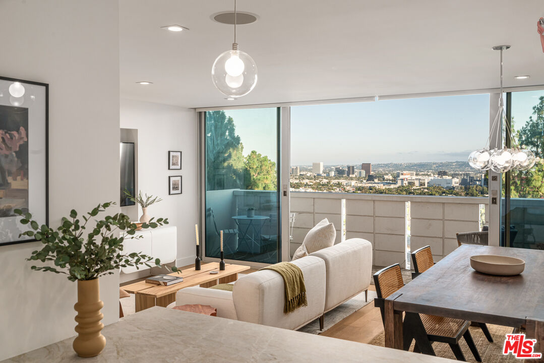 a living room with furniture potted plant and a large window