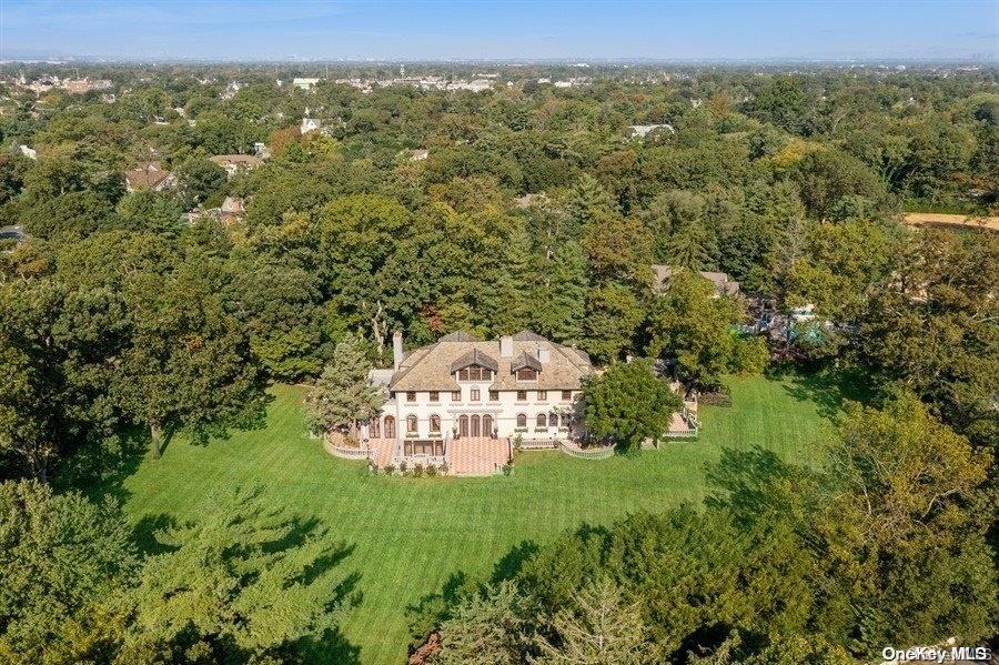 a view of a green yard with large trees