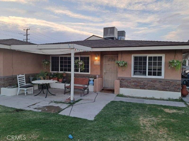 a front view of a house with a garden and sitting area