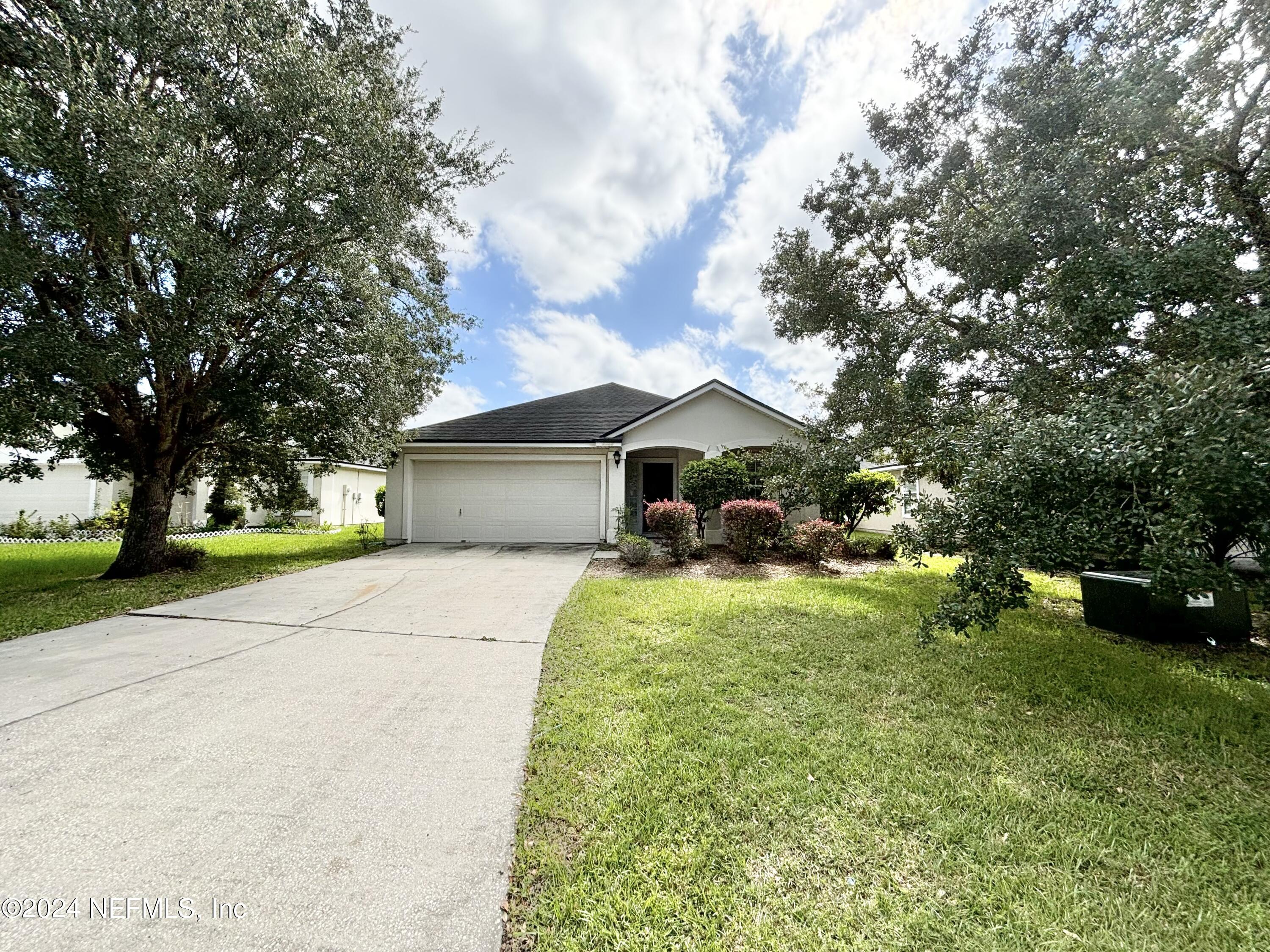 a front view of house with yard and trees