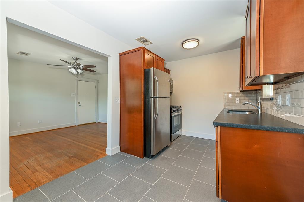 a kitchen with granite countertop a refrigerator and a sink