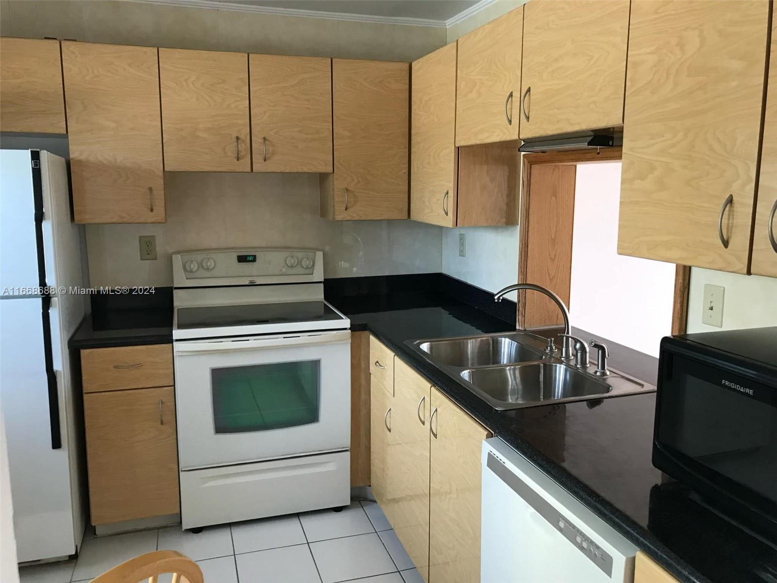 a kitchen with cabinets appliances a sink and a counter top