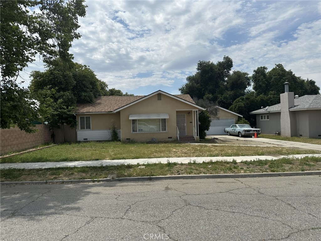 a front view of house with yard and trees around