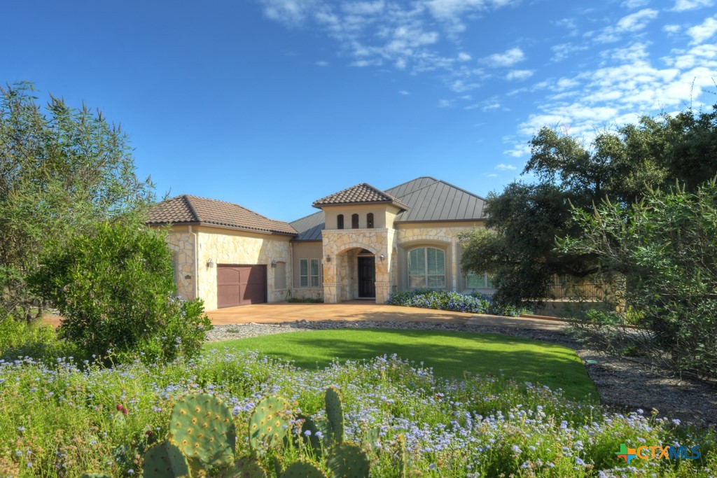 a front view of a house with a big yard and large trees