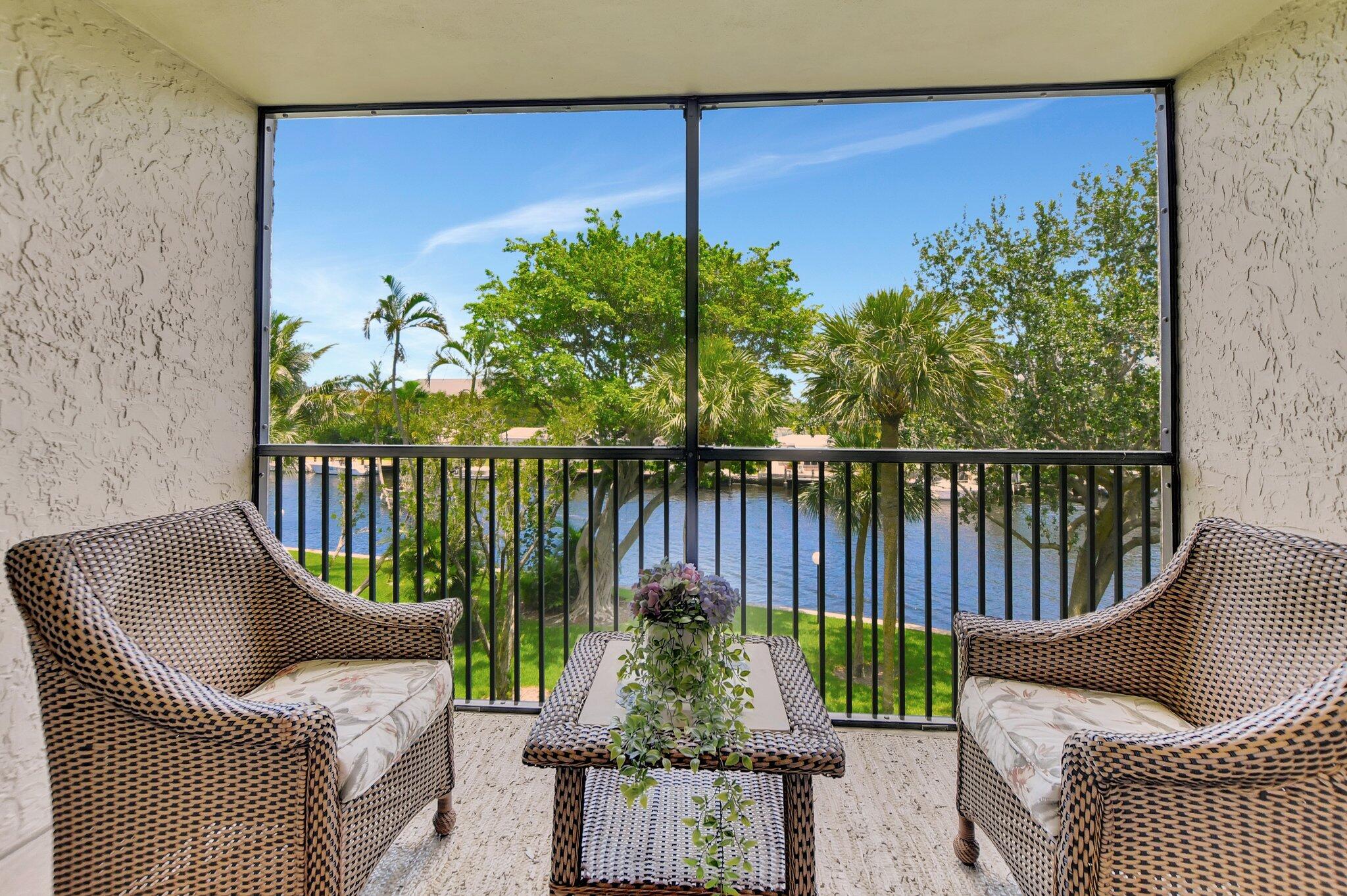 a balcony with wooden floor table and chairs