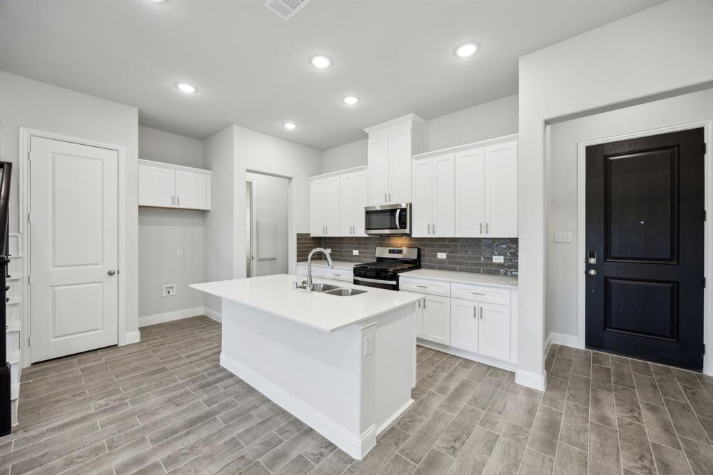 a kitchen with white cabinets and stainless steel appliances